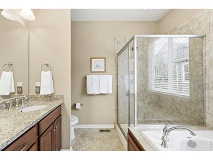 a bathroom with a granite countertop sink mirror and a bathtub