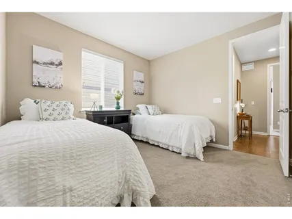 a bedroom with two bed and a large window