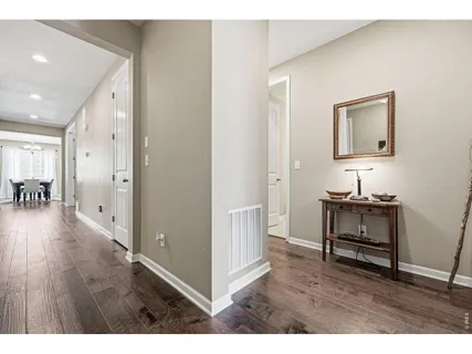 a hallway with wooden floor and furniture