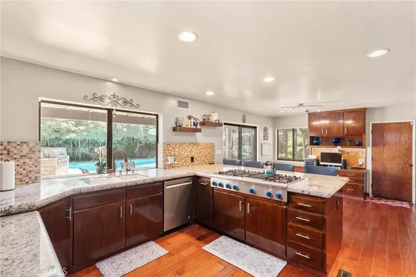 a dining room with stainless steel appliances a table and chairs