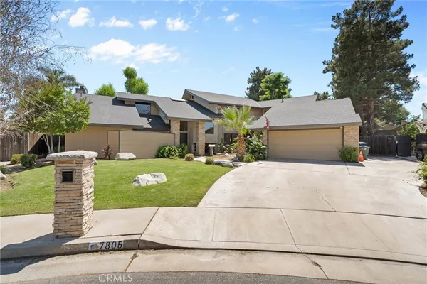 a front view of a house with a yard and a garage