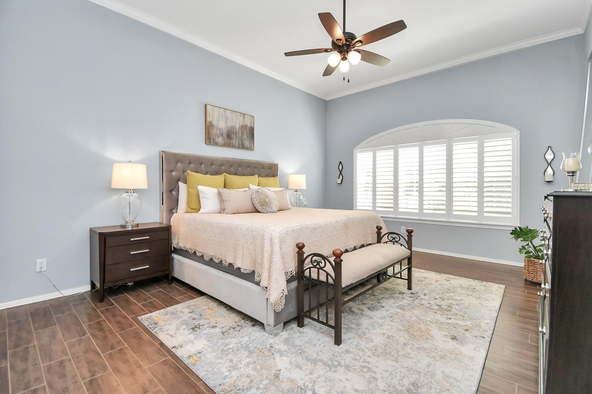 8624 Sunset Loch Drive Spring, TX 77379 - Photo 19 of 44 a spacious bedroom with a bed a chandelier and a window