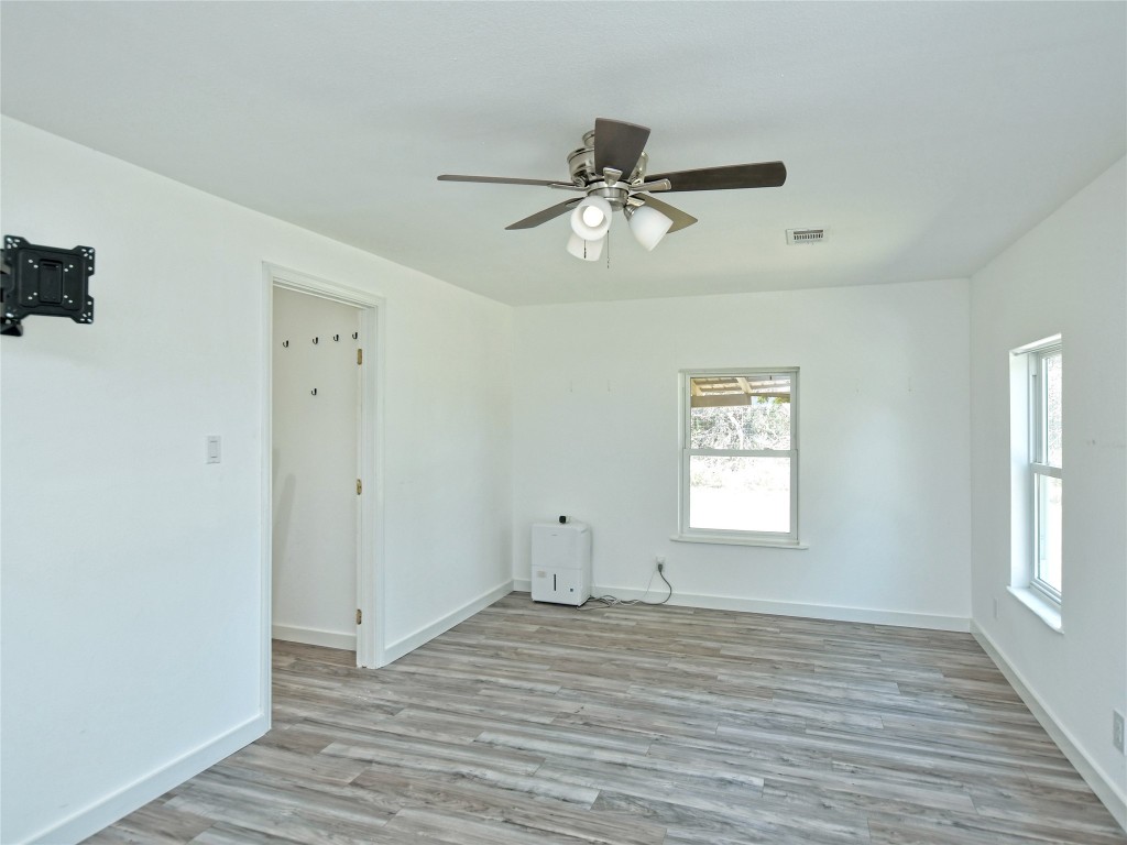 1000 County Road 484 Elgin, TX 78621 - Photo 20 of 30 a view of empty room with wooden floor and fan