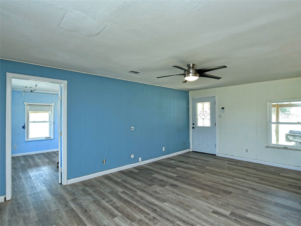 1000 County Road 484 Elgin, TX 78621 - Photo 7 of 30 a view of a livingroom with wooden floor and a ceiling fan