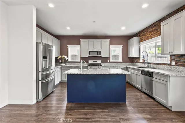 a kitchen with granite countertop a sink and a white wooden cabinets