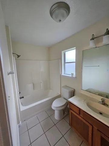 a bathroom with a granite countertop sink a toilet and shower