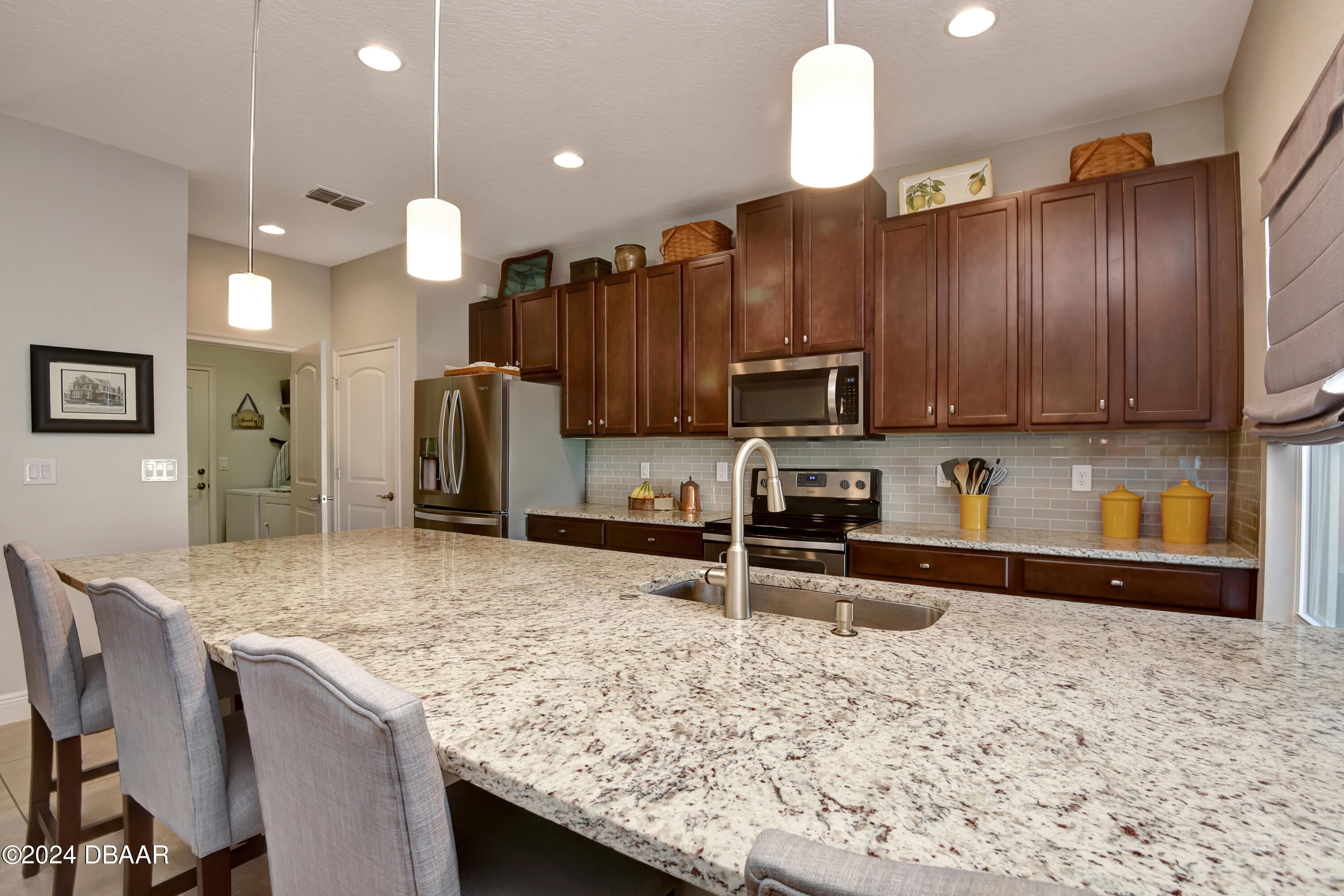 5430 Estero Loop Port Orange, FL 32128 - Photo 11 of 66 a kitchen with stainless steel appliances granite countertop wooden cabinets a stove a sink and a white refrigerator