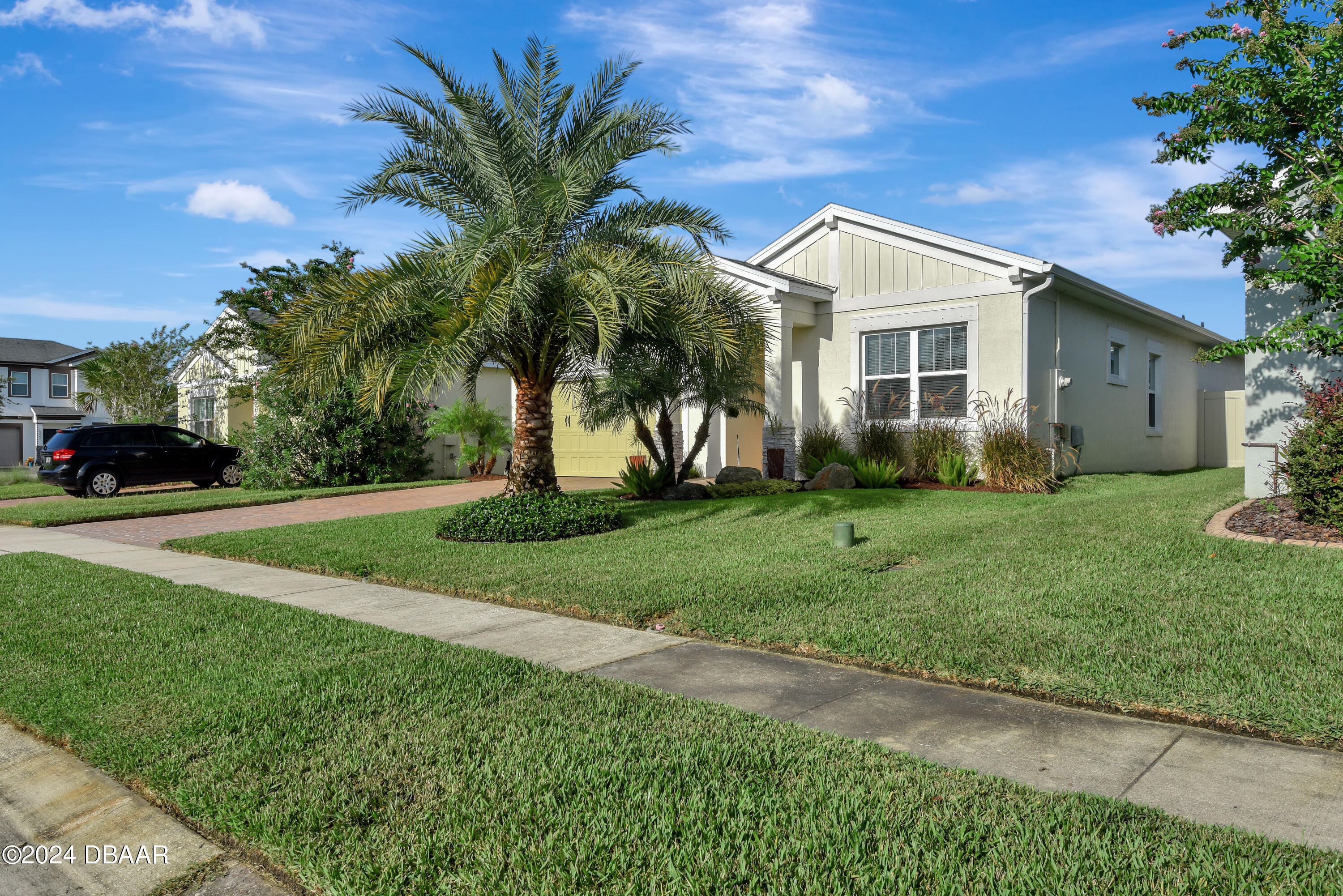 5430 Estero Loop Port Orange, FL 32128 - Photo 47 of 66 a view of a white house next to a yard with potted plants and palm trees