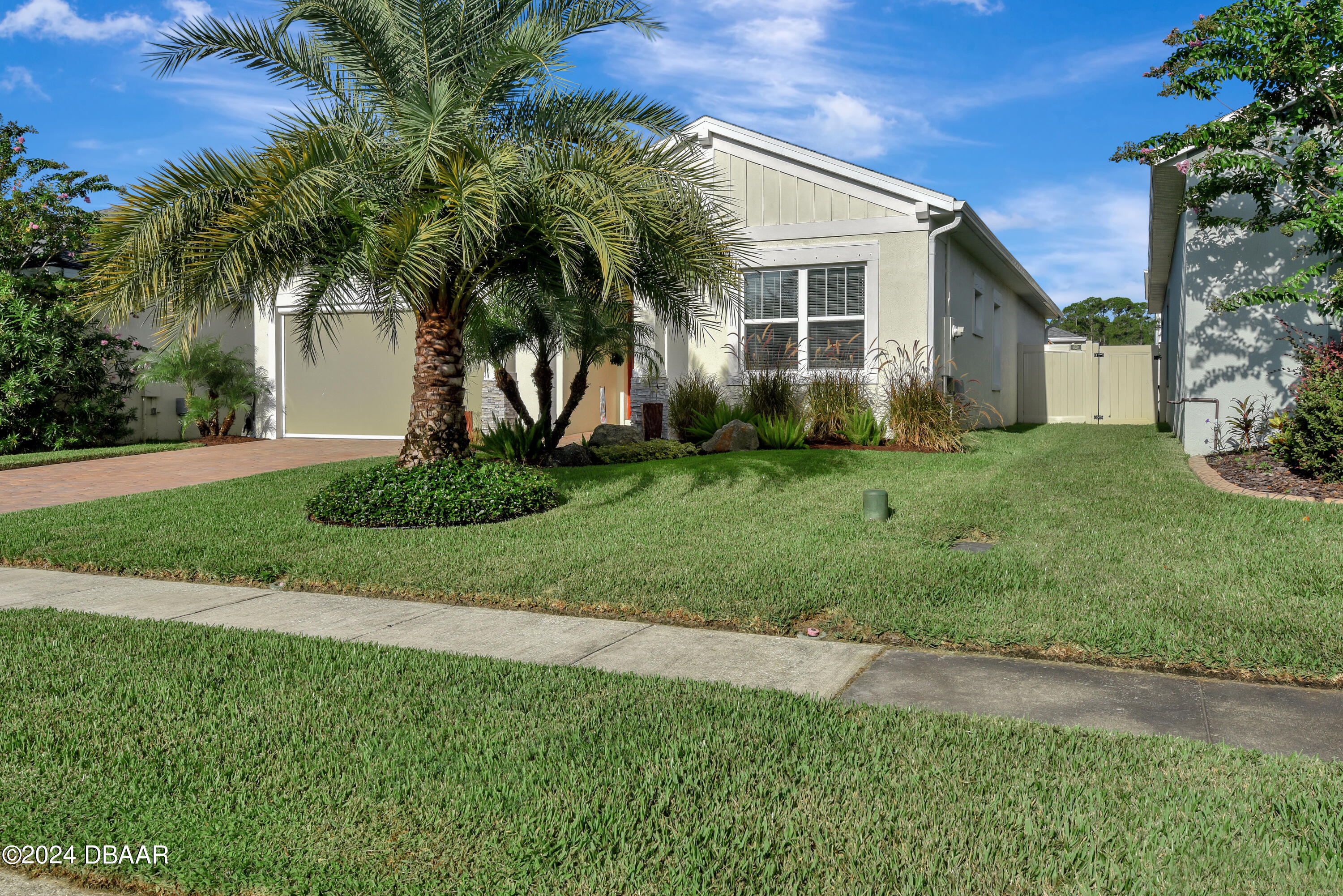 5430 Estero Loop Port Orange, FL 32128 - Photo 51 of 66 a front view of a house with a garden and palm tree