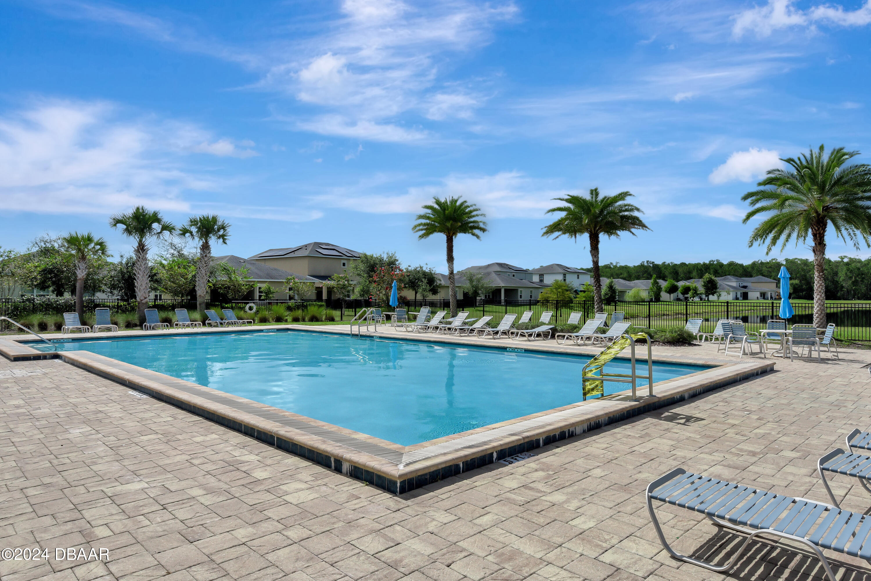 5430 Estero Loop Port Orange, FL 32128 - Photo 59 of 66 a view of a swimming pool with a lounge chair and palm trees