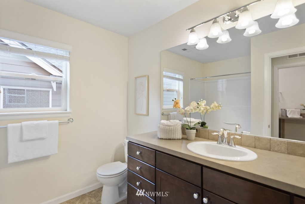 16232 Southeast 139th Court Renton, WA 98059 - Photo 17 of 23 a bathroom with a granite countertop sink a toilet and a mirror