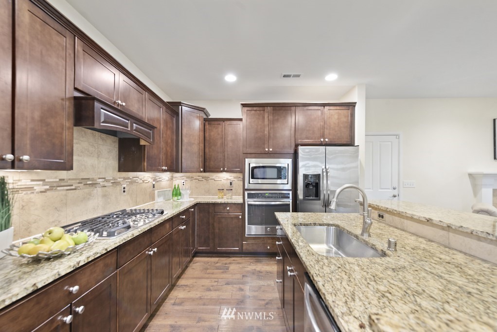 16232 Southeast 139th Court Renton, WA 98059 - Photo 8 of 23 a large kitchen with stainless steel appliances granite countertop a sink stove and refrigerator