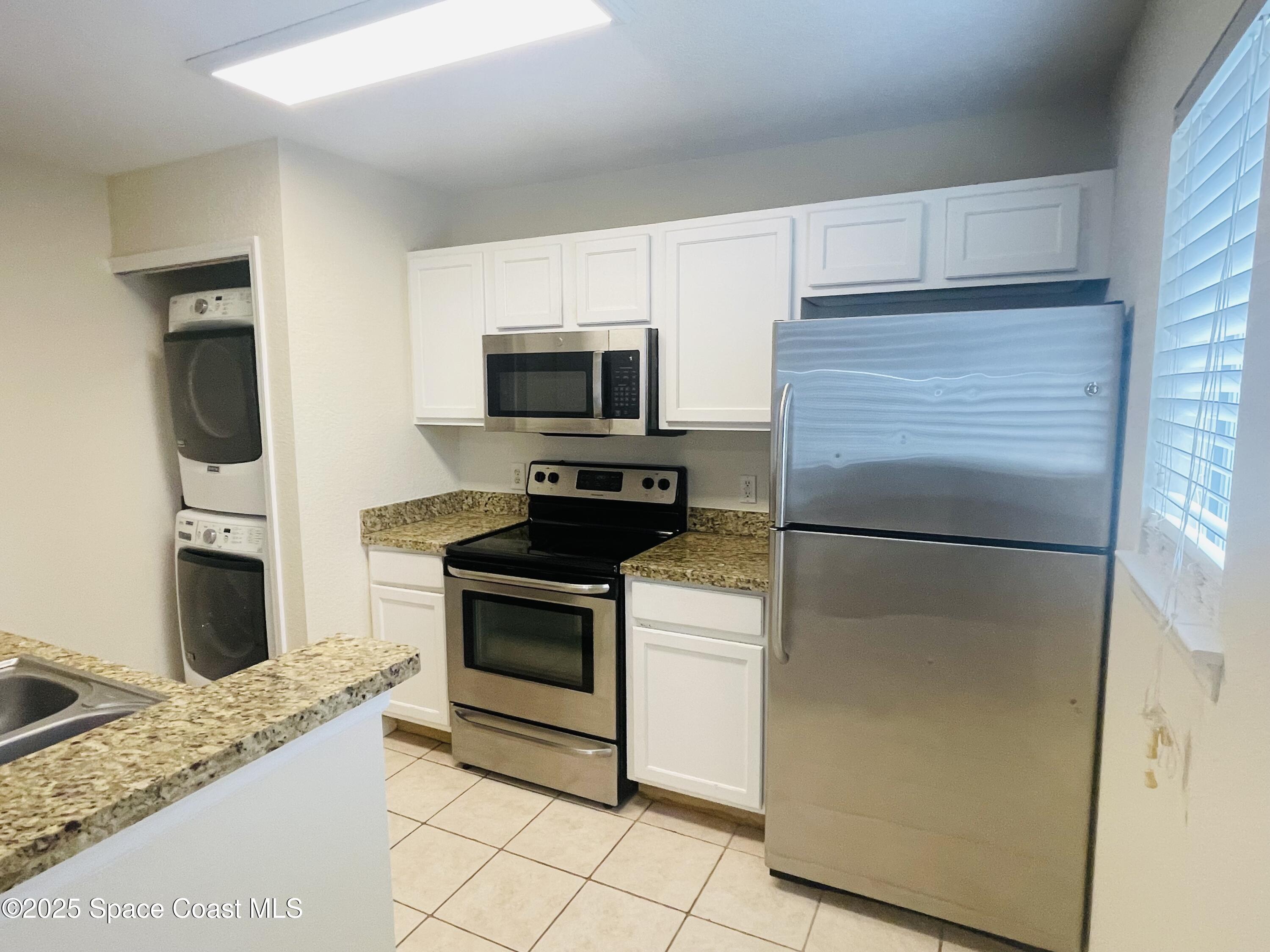 3501 D D'Avinci Way, Unit 1011 Melbourne, FL 32901 - Photo 2 of 19 a kitchen with a refrigerator stove and microwave