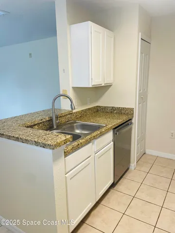 a kitchen with granite countertop white cabinets and white appliances
