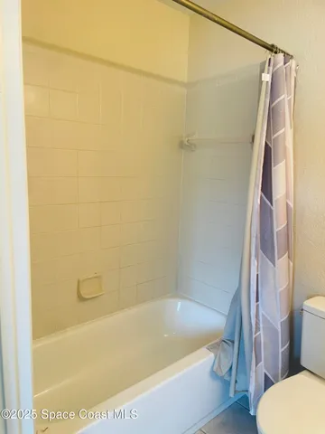 a bath tub sitting next to a white toilet