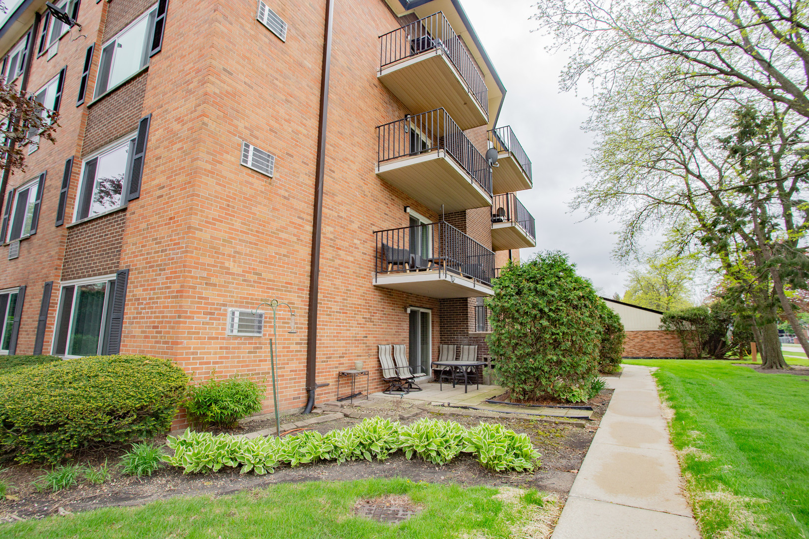 1217 South Old Wilke Road, Unit 201 Rolling Meadows, IL 60005 - Photo 22 of 26 a front view of a house with yard and green space