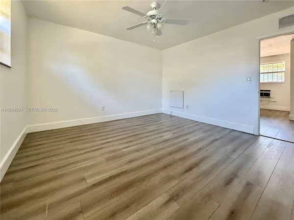 wooden floor in an empty room with a window