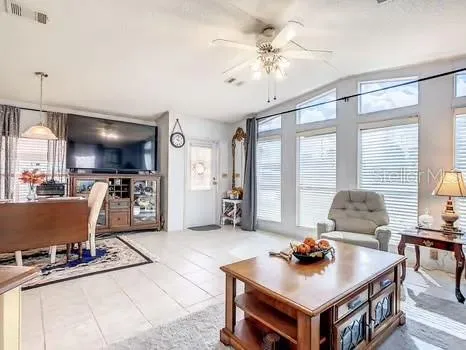 a living room with furniture a flat screen tv and kitchen view
