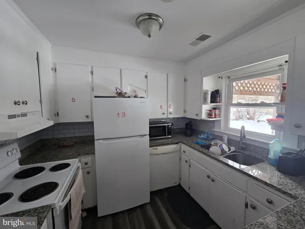 a kitchen with a refrigerator a sink and cabinets