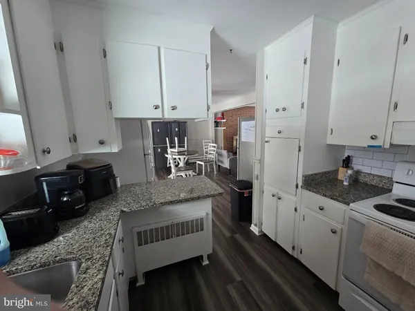 a kitchen with granite countertop a sink stove and cabinets