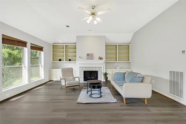a living room with furniture a fireplace and a large window