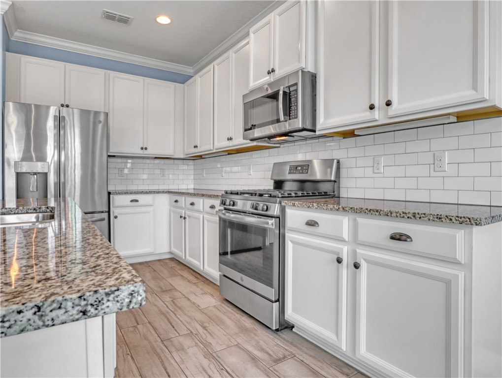 1756 Willows Square Vero Beach, FL 32966 - Photo 12 of 35 a kitchen with stainless steel appliances granite countertop a stove a sink and white cabinets