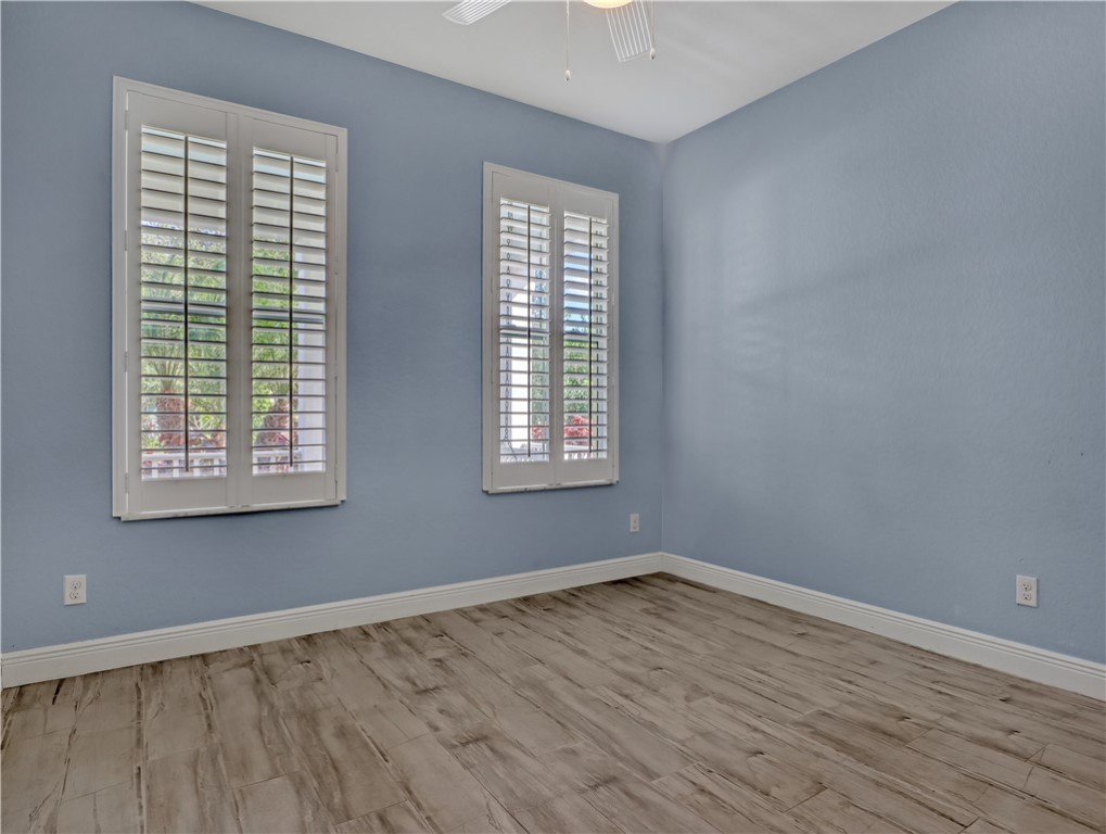 1756 Willows Square Vero Beach, FL 32966 - Photo 23 of 35 an empty room with wooden floor and windows