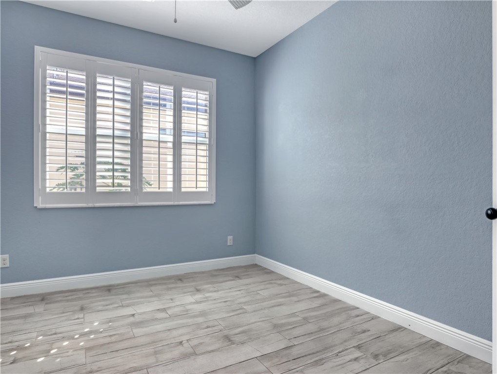 1756 Willows Square Vero Beach, FL 32966 - Photo 27 of 35 an empty room with wooden floor and windows