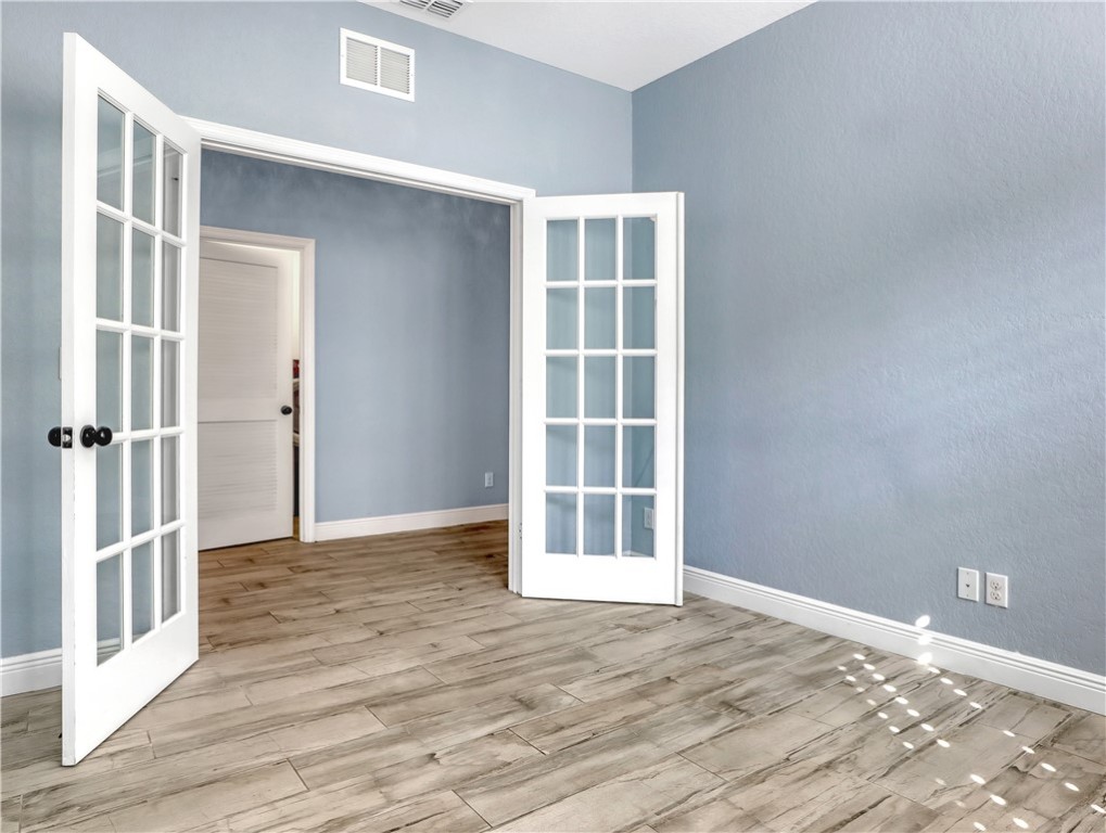 1756 Willows Square Vero Beach, FL 32966 - Photo 29 of 35 an empty room with wooden floor and windows