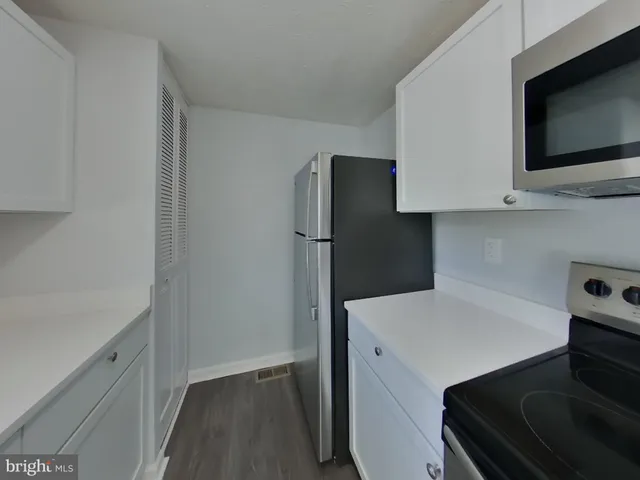 a kitchen with a refrigerator and a stove top oven