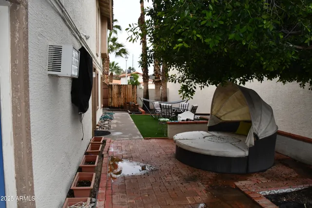 a view of a couches in the patio with a small yard