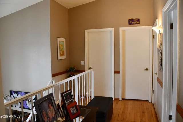 a view of a hallway with wooden floor and stairs