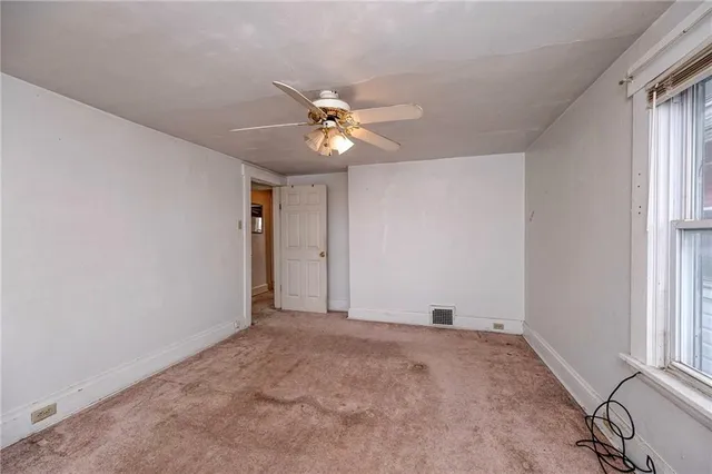 a view of a big room with chandelier fan and windows