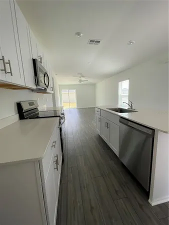 a kitchen with cabinets and wooden floor
