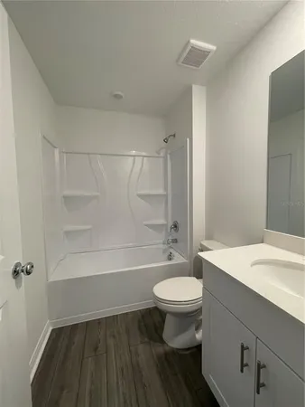 a bathroom with a sink a toilet a mirror and bathtub