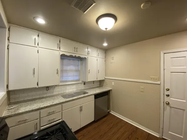 a room with a sink cabinets and wooden floor