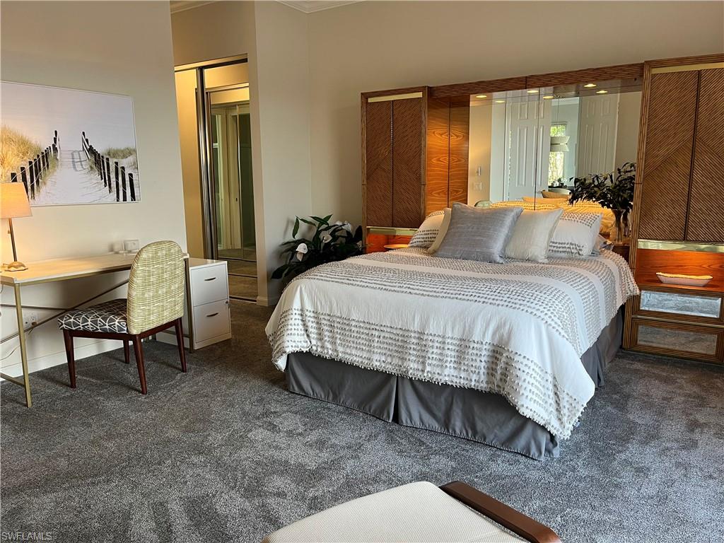 5477 Freeport Lane Naples, FL 34119 - Photo 13 of 36 a bedroom with a bed and a table in it
