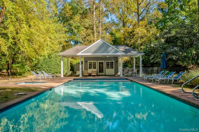 a front view of a house with swimming pool having outdoor seating