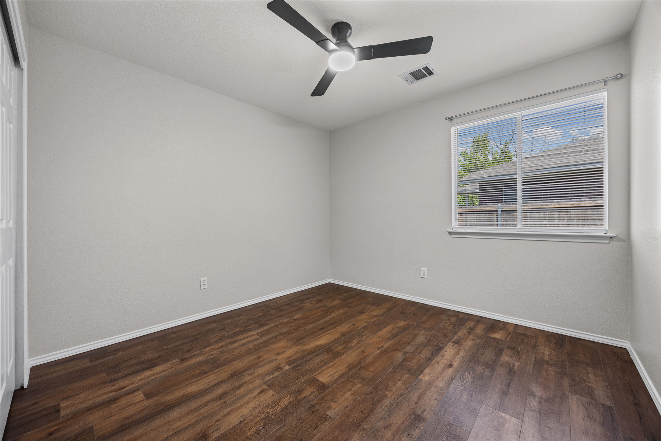 1524 Lochaline Loop Pflugerville, TX 78660 - Photo 16 of 22 A quiet retreat, this bedroom offers durable wood flooring and a contemporary ceiling fan for year-round comfort.