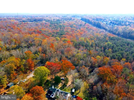 an aerial view of a houses with a lush green hillside