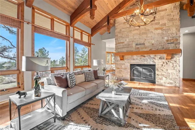 a living room with furniture a fireplace and large windows