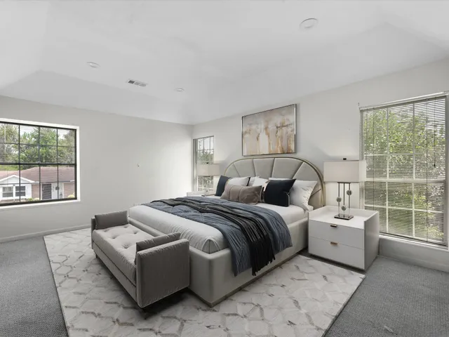 a bedroom with a bed and a large window