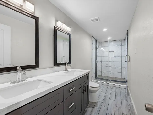 a bathroom with a sink a toilet and shower