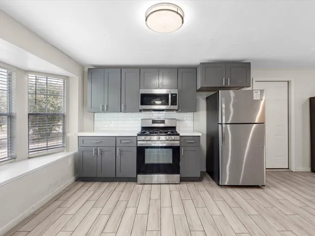 a kitchen with a refrigerator sink and wooden cabinets