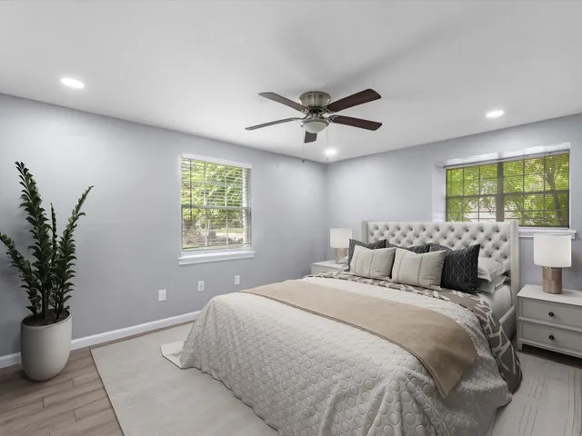 a bedroom with a large bed and a potted plant