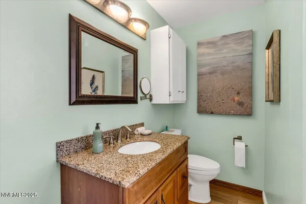 a bathroom with a granite countertop sink a mirror and shower