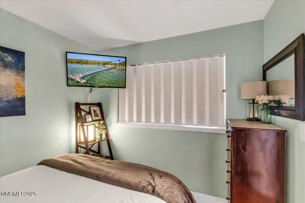a bedroom with a bed and a painting on the wall