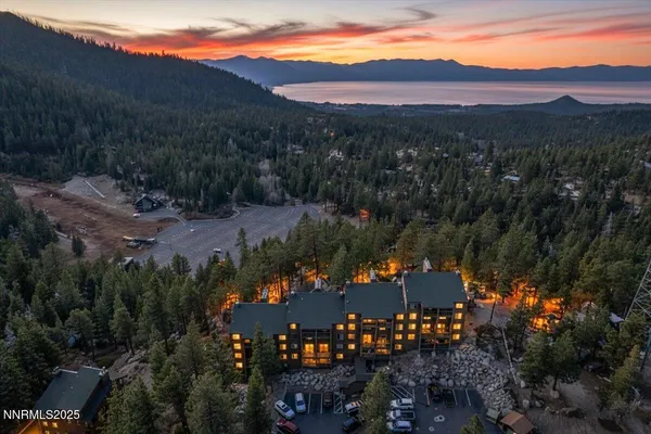 a front view of a building with glass windows and a yard
