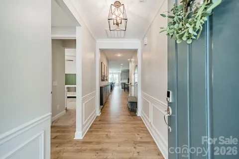 a view of a hallway with wooden floor and staircase