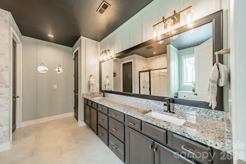 a bathroom with a granite countertop sink and a large mirror